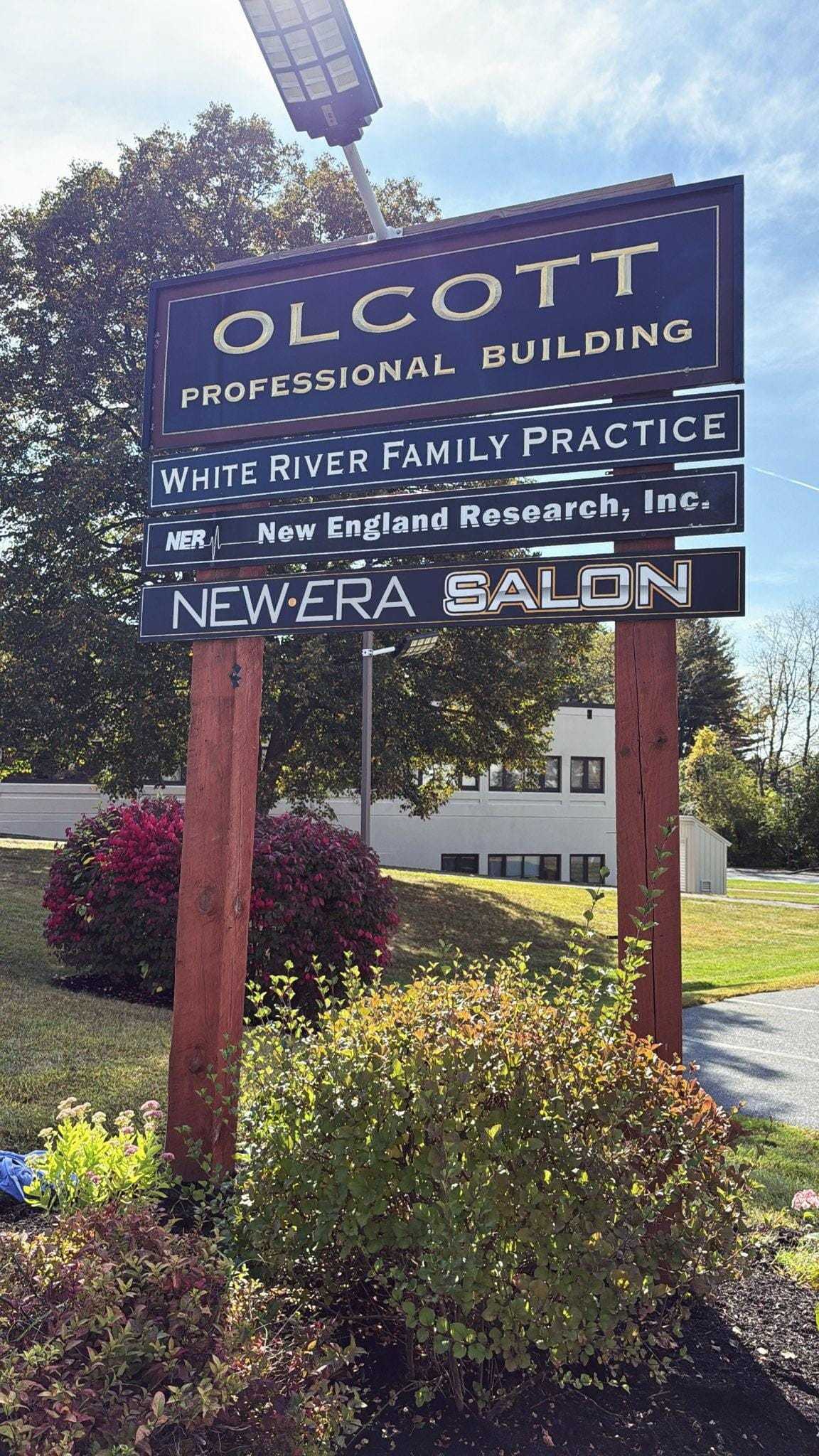 Professional building sign with family practice, research, and salon businesses.