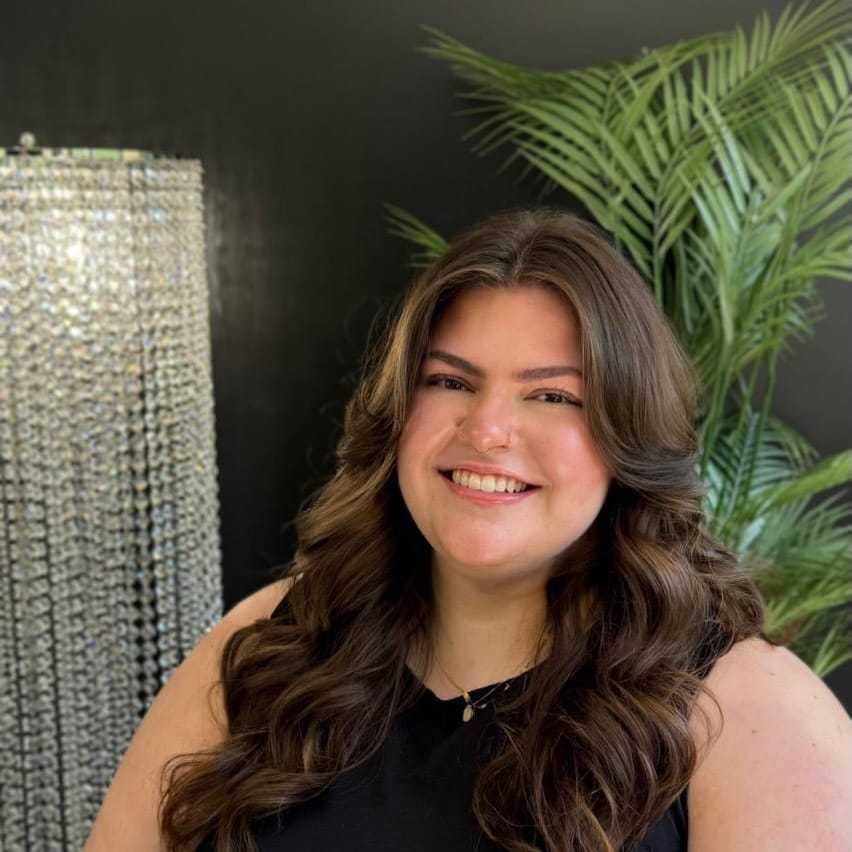 Portrait of Olivia, a professional stylist at New Era Salon, showcasing their expertise and style.