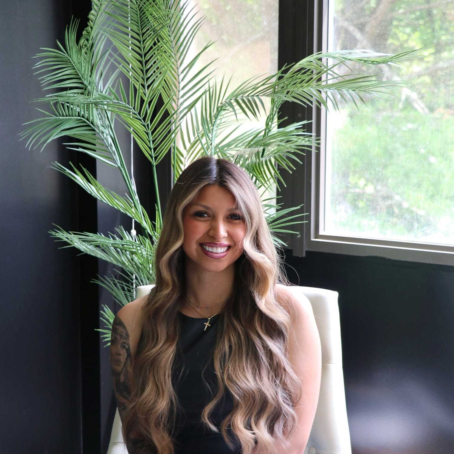 Portrait of Paige, a professional stylist at New Era Salon, showcasing their expertise and style.